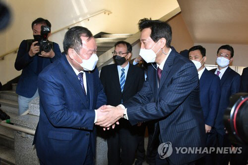 서울시의회 방문한 오세훈(오른쪽) 시장이 김인호 의자와 악수하고 있다. <연합뉴스>